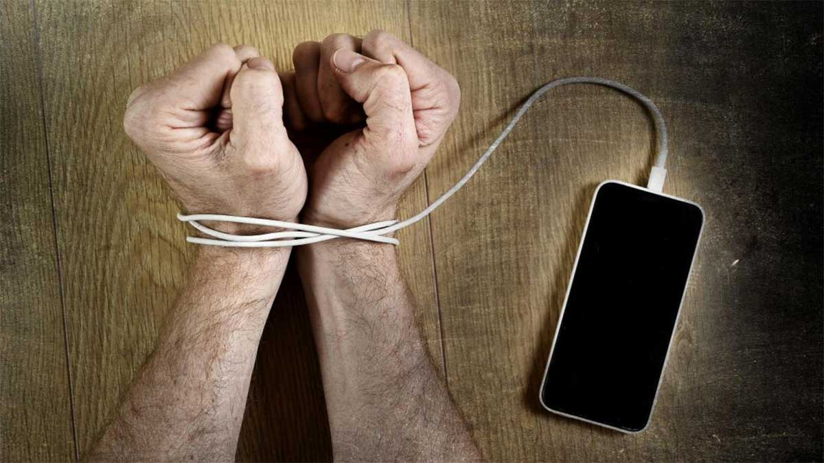 A hand tied to a cable that's attached to a smartphone