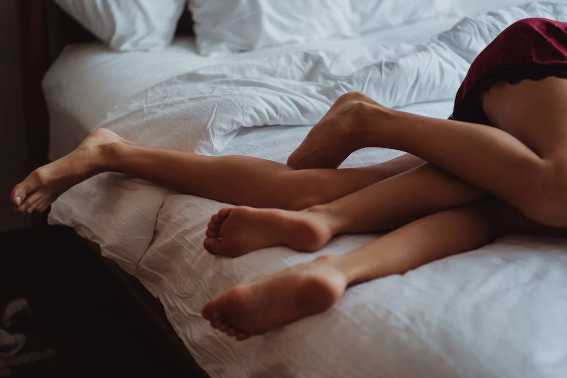 Image showing the legs of two people on a bed, symbolizing the complexities addressed in sex addiction treatment.