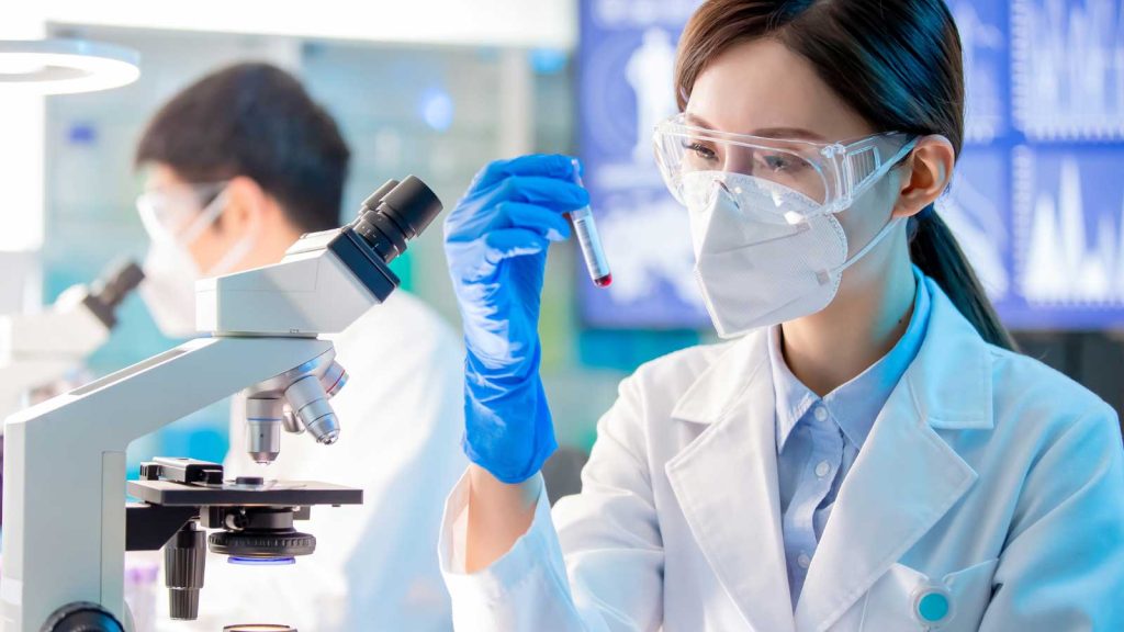 A scientist examines a blood sample in a laboratory setting