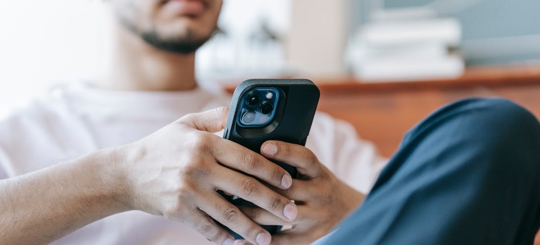 a man using his phone to learn what is the connection between ADHD and Porn Addiction