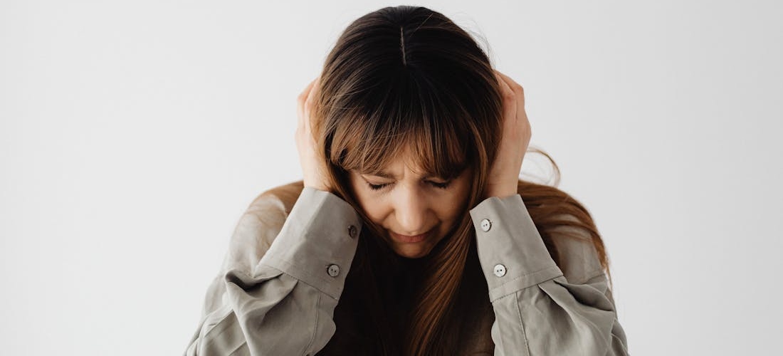 A person holding their head in frustration, showing the emotional strain of anxiety and alcohol