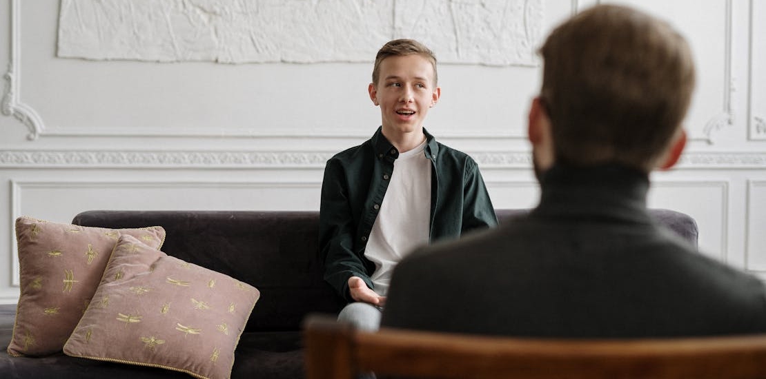 A teenager talking to a physiatrist about growing up with alcoholic parents affects children