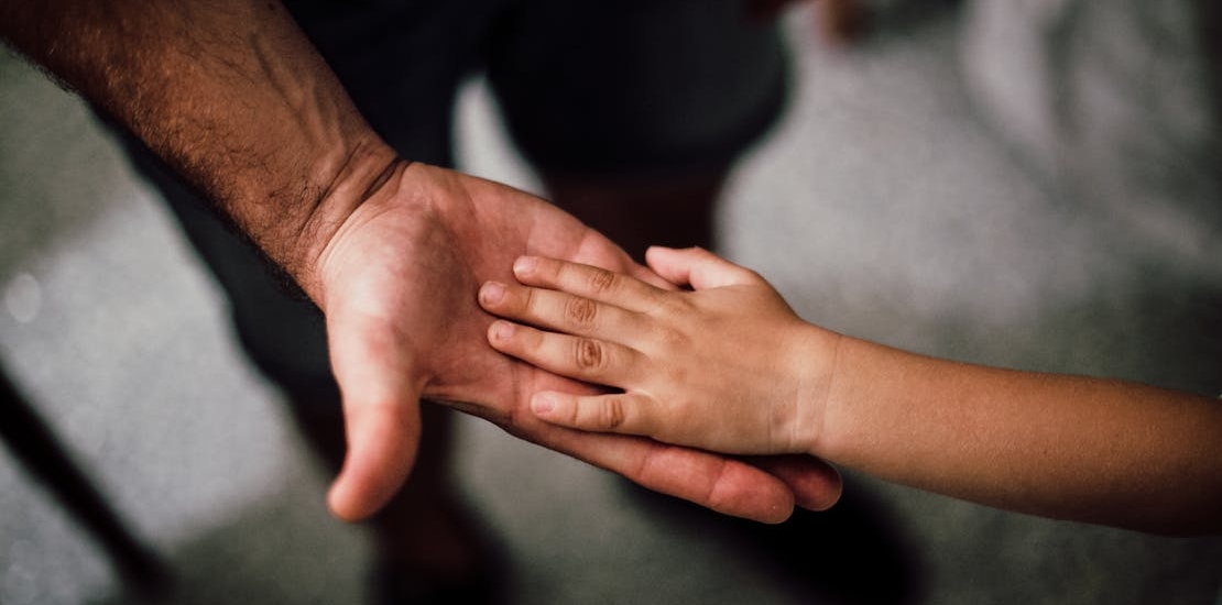 A child and a parent holding hands