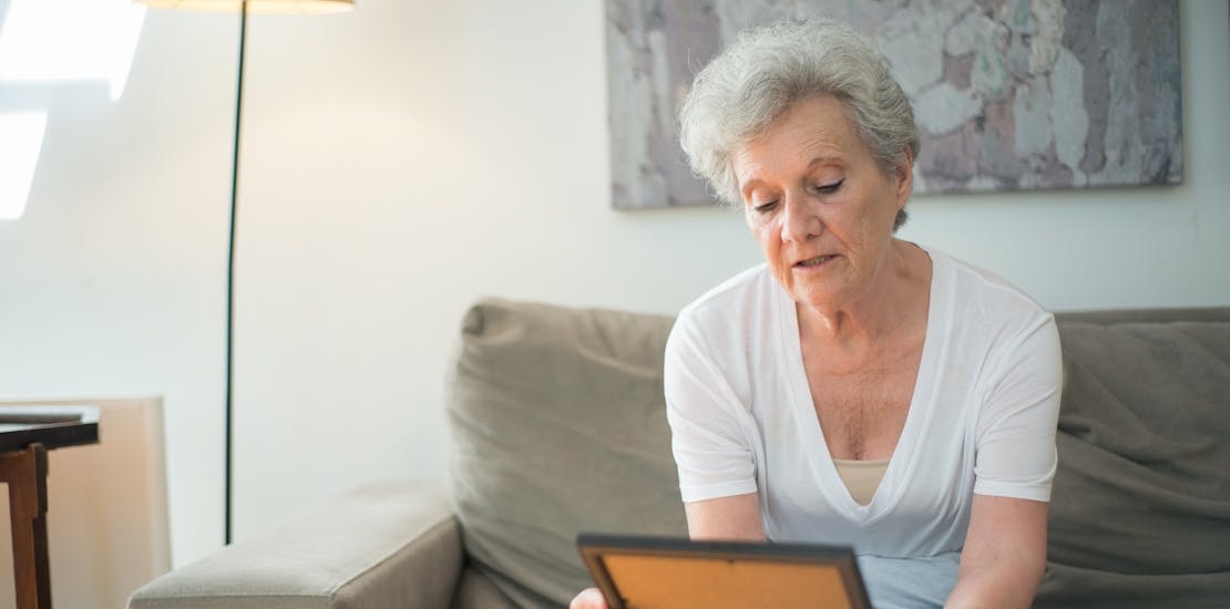 an elderly woman looking at a photo