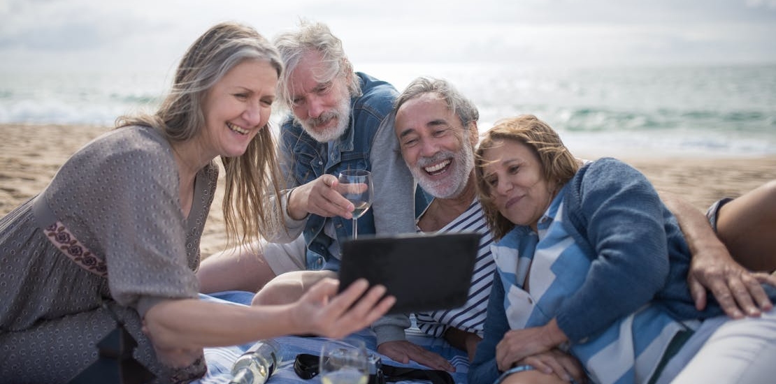 a group of seniors at the beach talking about how to lower the risk of depression in the elderly