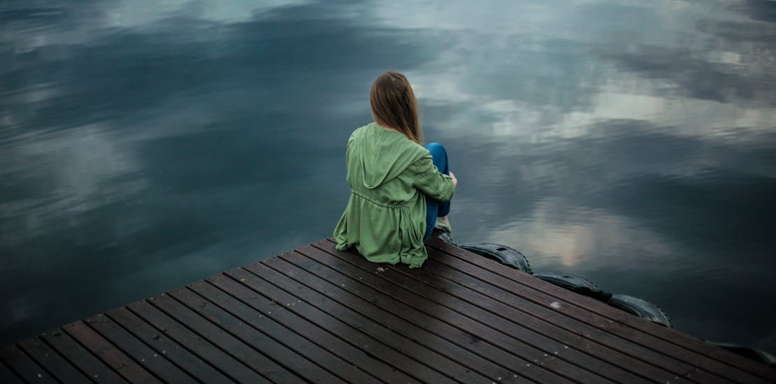 A woman sitting near the water