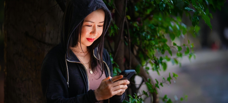 Person looking thoughtfully at a smartphone.