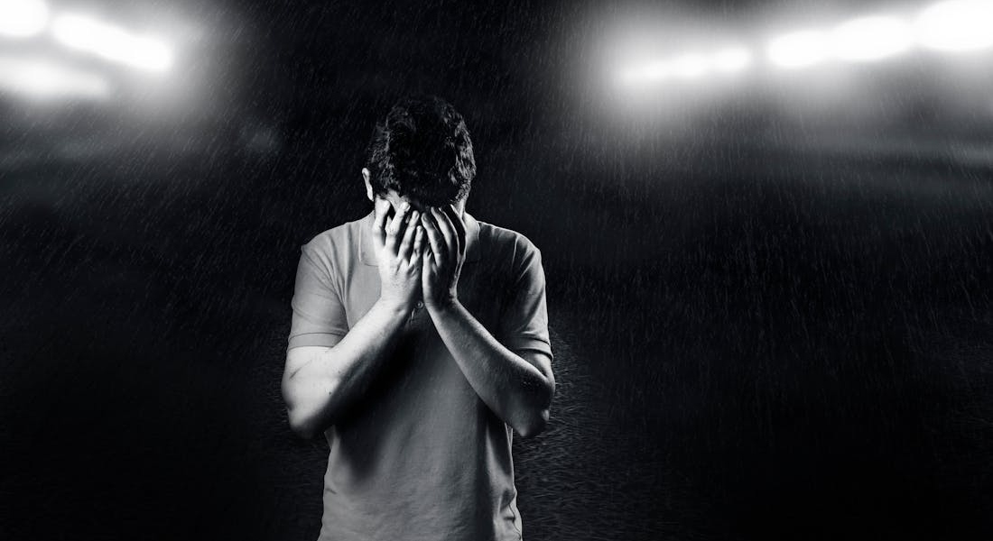 man covering his face